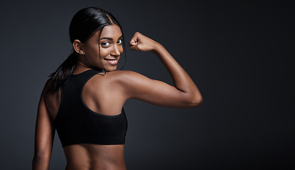 Image showing Portrait, smile and woman flexing back in studio isolated on a black background mockup. Strong flex, happy and Indian female athlete with bicep, arm strength or bodybuilder muscle, fitness or workout