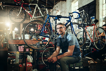 Image showing Portrait, wrench and serious repair man in bicycle shop, store or cycling workshop. Face, bike mechanic and male person, business owner or mature professional technician with glasses and confidence.