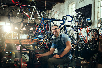 Image showing Portrait, wrench and smile of repair man in bicycle shop, store or cycling workshop. Face, bike mechanic and male person, happy business owner or mature technician with glasses and confidence.