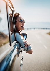 Image showing Happy, freedom and road trip with a woman in a car, looking at the view from the window while on the open road. Smile, travel and fun with a young female traveler on a journey during her vacation