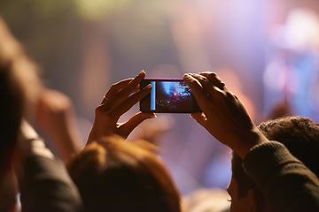 Image showing Music, concert and phone camera in the audience to record a performance on stage at a festival or event. Party, video or photograph with a person in the crowd of a stadium at night holding a mobile