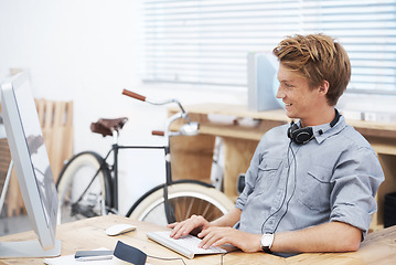 Image showing Man, startup office and typing with smile, computer and creativity for post on social media website. Young businessman, entrepreneur and seo expert on web with happiness at small business by computer