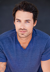 Image showing Portrait, fashion and beauty with a sexy man in studio on a gray background for contemporary style. Face, happy and blue eyes with a handsome young male model posing in modern or stylish clothes