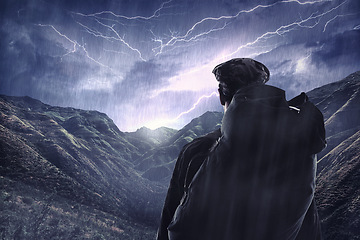 Image showing Lightning storm, travel and a man hiking from the back in the mountains during the night with winter rain. Dark sky, gray clouds and stormy weather with a male hiker outdoor in dangerous conditions