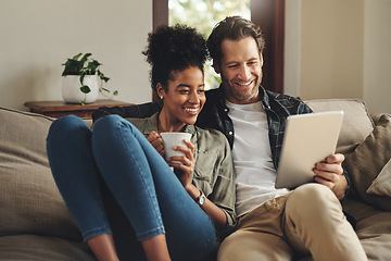 Image showing Relax, home and interracial couple on a couch, tablet and happiness with social media and connection. Partners, man and woman on a sofa, technology and loving with a smile, romance and online reading