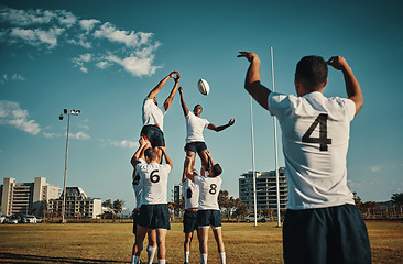 Image showing Team, rugby and jump or lift, ball and teamwork or sport, training for game and fitness, exercise or sports performance with blue sky. Group, men and lifting man to catch and professional match