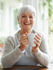 Image showing Portrait, happy old woman and drinking coffee in home for break, relaxing morning and retirement. Face, laughing and senior lady enjoy cup of tea, warm beverage and hot drink in house with happiness