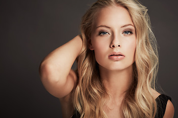 Image showing Makeup, beautiful and portrait of a woman with confidence isolated on a dark background in a studio. Young, confident and the face of a cosmetics model looking gorgeous with a facial cosmetic look