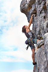 Image showing Rock climbing, fitness and blue sky with woman on mountain for adventure, travel and explore. Strong, freedom and cliff with female climber training in nature for courage, safety and workout