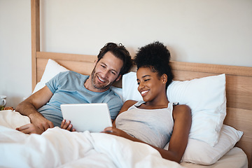 Image showing Happy couple, tablet and relax on bed for entertainment, movie or online streaming together at home. Interracial man and woman relaxing, morning or watching on technology or social media in bedroom
