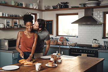 Image showing Interracial couple, kiss and cooking breakfast in kitchen for morning, love or care in marriage at home. Happy man kissing woman for food, nutrition or hug in happiness for healthy relationship