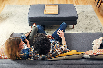 Image showing Top view, couple and relax on sofa in living room for quality time, love and care of conversation, communication or chat. Happy man, woman and talking on couch for break, bonding and together at home