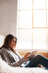 Image showing Window, tablet and credit card with a woman online shopping on a sofa in the living room of her home. Ecommerce, finance and fintech banking with a young female user, customer or shopper in a house