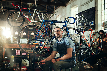 Image showing Portrait, tools and serious repair man in bicycle shop, store or cycling workshop. Face, bike mechanic and male person, business owner or mature professional technician with glasses and confidence.