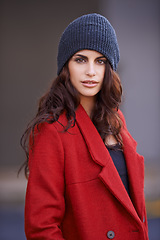 Image showing Portrait, fashion and woman with winter clothes, outdoor and confident girl in the city. Face, female person or model with a red winter coat, beanie or stylish outfit with lady in the road or street