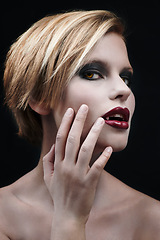 Image showing Portrait, hand and a woman vampire in studio on a dark background as a cosplay monster. Fantasy, horror or scary with an attractive young halloween female person posing as an evil and supernatural