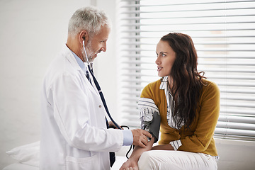 Image showing Doctor, blood pressure and a woman patient at hospital for a consultation with health insurance. Man with a stethoscope to check pulse of person for medical exam, wellness and hypertension diagnosis