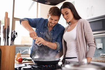 Image showing Happy couple, pan and cooking together in the kitchen with food or healthy ingredients for dinner at home. Man and woman smiling in happiness for meal preparation, lunch or frying vegetables on stove