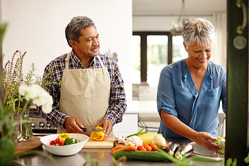 Image showing Food, elderly couple and cooking while happy in kitchen of their home. Teamwork or help, vegetables and senior married people preparing a meal for dinner or lunch together in their house.