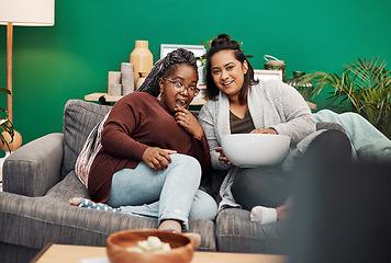 Image showing Girl friends, tv and surprise in home living room on a couch with a happy smile. Series, movie and women together in a lounge with a female friend looking at a television in house with popcorn