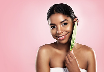 Image showing Portrait, happy woman and leaf for skincare in studio, pink background and mockup of vegan dermatology. Face, african model and leaves for eco friendly beauty, natural glow or cosmetic sustainability