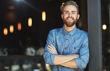 Image showing Portrait, happy and man in a cafe, arms crossed and startup success with employment, business owner or joyful. Face, male employee or confident entrepreneur with a smile, coffee shop and professional