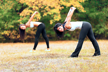 Image showing Women, yoga stretching and portrait in a outdoor park for exercise and fitness. Health, wellness and arm warm up of female friends in nature on grass feeling happy with smile from body care and sport