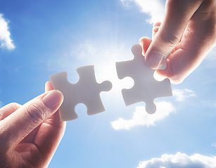 Image showing Hands, puzzle and blue sky with business people team building a solution outdoor from below. Collaboration, teamwork and problem solving with colleagues holding jigsaw pieces for strategy or planning