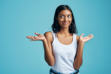 Image showing Options, thinking and woman with a gesture in a studio with a confused, unsure or uncertain face. Decision, doubt and Indian female model with choice or shrug hand sign by blue background with mockup