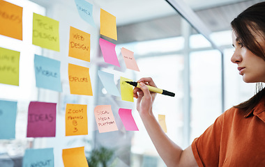 Image showing Woman writing notes, brainstorming with ideas on glass board and sticky note, planning in office with focus. Creative project, agenda and female employee working, strategy and storyboard with goals