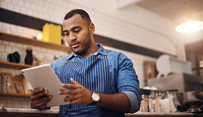 Image showing Focus, tablet and manager with man in cafe for online, entrepreneurship and startup. Waiter, technology and food industry with small business owner in restaurant for barista, african and coffee shop