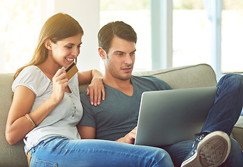 Image showing Couple, laptop and credit card for online shopping on home sofa with secure fintech payment on website. A man and woman together on a couch while happy about e-commerce and internet connection