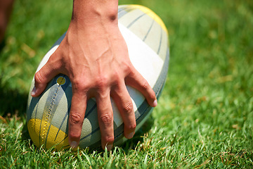 Image showing Rugby player, ball sports and hand of a man while outdoor on a pitch wit green grass or lawn. Male athlete person playing in sport competition, game or training match for fitness, workout or exercise