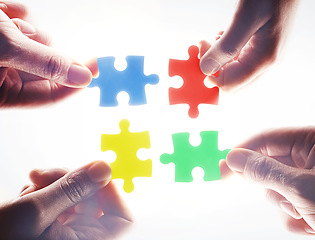 Image showing Hands, puzzle and teamwork in group, problem solving or together for support, glow or color by white background. Team building, jigsaw or strategy for innovation, synergy or solution in collaboration