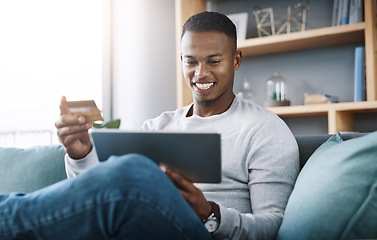 Image showing Online shopping, tablet and happy man with credit card on couch surfing website for discount sale or promotion. Happiness, internet payment and smile, man on digital ecommerce subscription service.