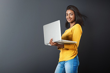 Image showing Laptop, portrait and woman typing online, internet or web email isolated in a studio grey background feeling happy. Mockup, social media and female student or person working and using technology