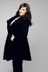 Image showing Woman, fashion and portrait of plus size model posing in winter clothing against grey studio background. Isolated female person standing with stylish black coat or warm fashionable clothes for beauty