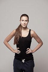 Image showing Woman akimbo, portrait and fitness confidence with arms on hip for body, health or wellness on a gray studio background. Happy and confident female person or model posing in cardio exercise clothing