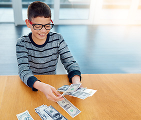 Image showing Savings, young child counting money and sitting at desk at his home. Finance or investing, financial management or wealth planning and happy male kid with cash for future investment in house