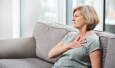 Image showing Heart attack, chest and senior woman with pain in her home living room or couch with an emergency or crisis on a sofa. Asthma, medical and sick elderly person with discomfort due to illness