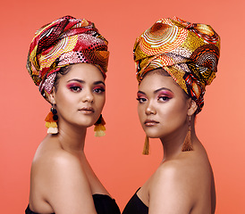 Image showing African fashion, beauty and portrait of women on orange background with cosmetics, makeup and accessories. Glamour, studio and face of female people with exotic jewelry, traditional style and luxury