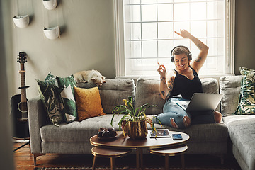 Image showing Dancing, headphones and woman on sofa and laptop, happy energy and mental health music in her home. Young person on couch listening to audio tech, electronics and podcast on computer in living room