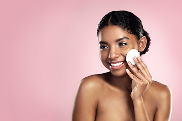 Image showing Skincare, mockup and happy woman with cotton pad on face, smile and makeup removal with skin product in studio. Dermatology, facial cleansing cosmetics and African model isolated on pink background.