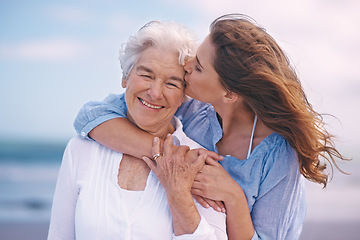 Image showing Woman, kiss and senior mother at beach with happiness, love and smile for mothers day on vacation. Elderly lady, daughter and happy with hug, bonding and outdoor by ocean for holiday in retirement
