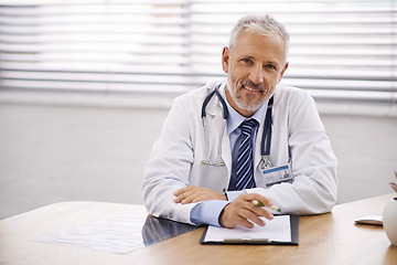 Image showing Happy, portrait and doctor with a clipboard in his office analyzing test results in a hospital. Confidence, smile and professional mature male healthcare worker sitting by his desk in medical clinic.