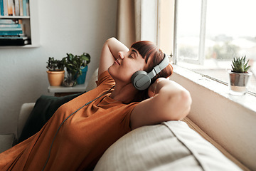 Image showing Relax, headphones and woman listening to music, podcast or radio while resting on a sofa. Calm, chill and female person streaming album, playlist or song while sleeping in the living room of her home