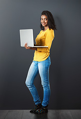 Image showing Portrait, happy indian woman standing with laptop and in wall background. Social media or networking, technology or communication and smiling African female worker with mockup in studio backdrop.