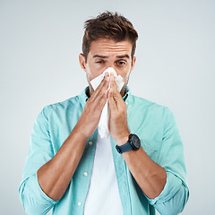 Image showing Sick, tissue and portrait of man blowing nose in studio with flu, illness and virus on white background. Health, wellness and face of male person with hayfever, cold symptoms and sneeze for allergy