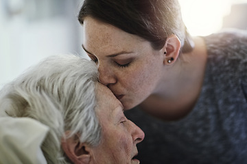 Image showing Senior, daughter and kiss mother in hospital for healthcare, visiting sick patient and resting. Clinic, woman and kissing elderly mom on forehead with love, care and empathy, kindness and comforting.