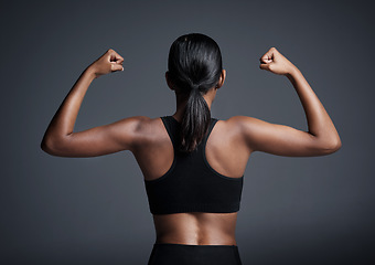 Image showing Sports, exercise and woman flexing back in studio isolated on a black background. Strong flex, muscle and female athlete with bicep, arm strength or bodybuilder training, fitness and healthy workout.